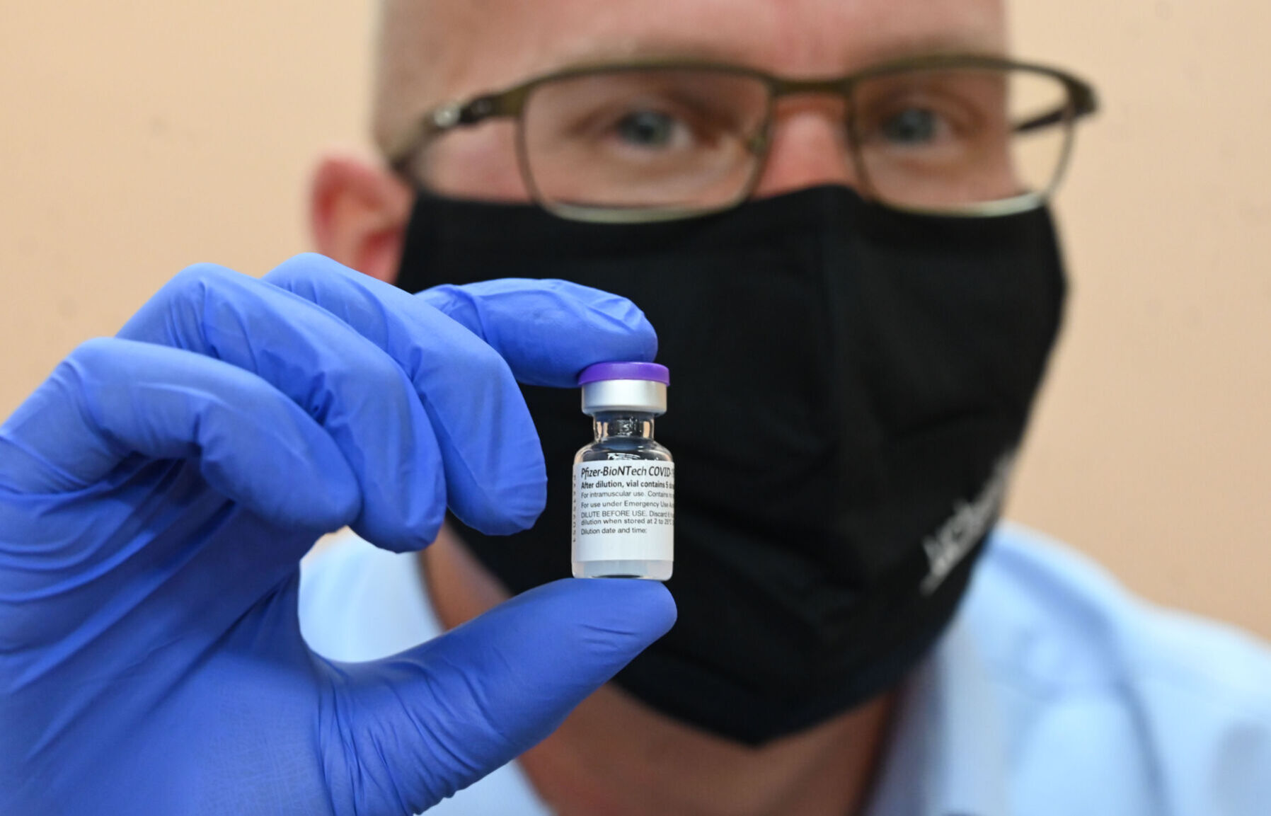 UCHealth pharmacist Chris Martin holds the first COVID-19 vaccine in Colorado Springs